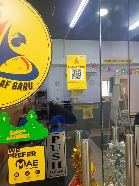 Pintu masuk kaca Pusat Tuisyen Alaf Baru dengan logo kuning